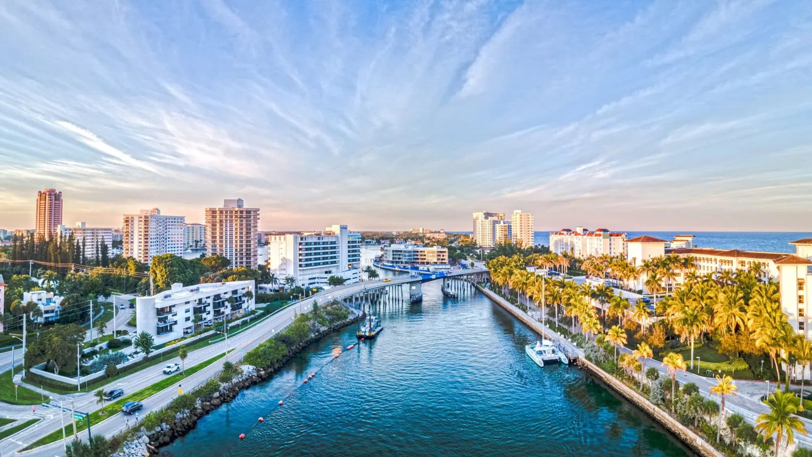 Aerial view of the Boca Raton inlet with condos, palms, and the Atlantic Ocean