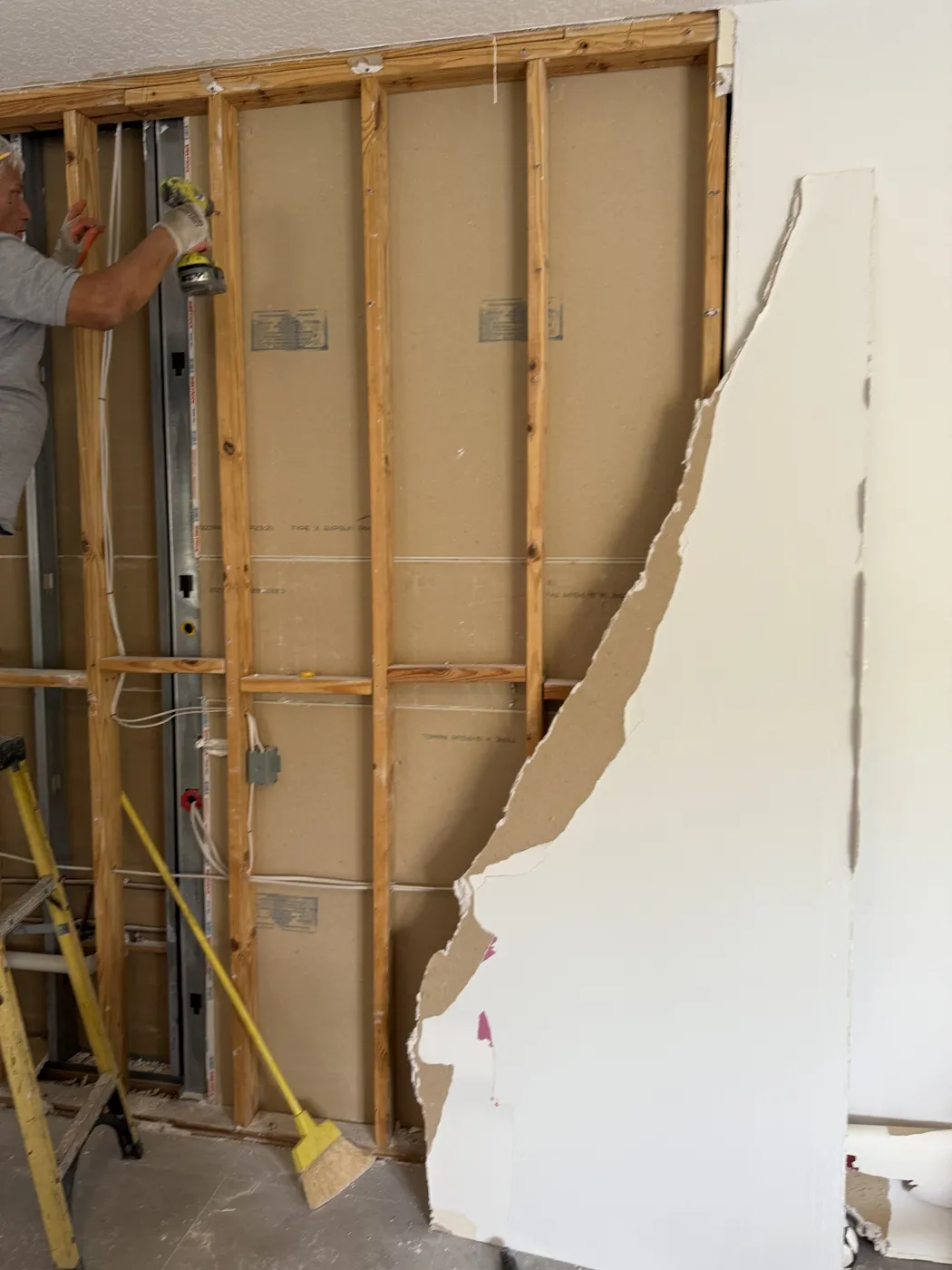 BO Renovation crew member removing drywall screws during selective demolition
