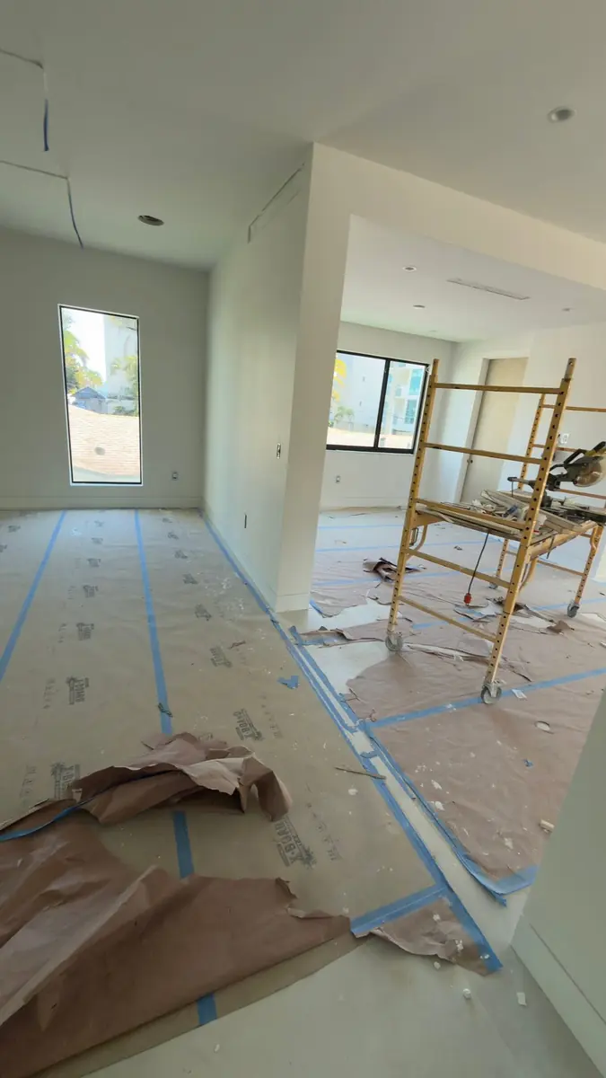 Newly painted interior rooms with a rolling scaffold and protected floors during finishing work